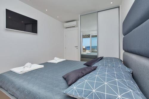 a bedroom with a blue bed and a television at Penthouse Bella Vista Makarska in Makarska