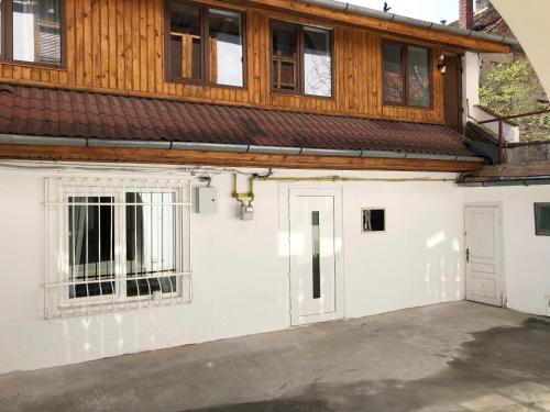 uma casa com garagem branca com telhado de madeira em Bb's Cosy Apartments em Braşov