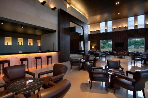 a restaurant with chairs and tables and a bar at Kempinski Hotel Ishtar Dead Sea in Sowayma