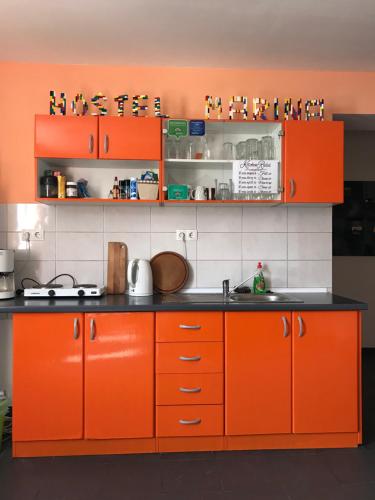 a kitchen with orange cabinets and a black counter top at Hostel Marina Trogir in Trogir