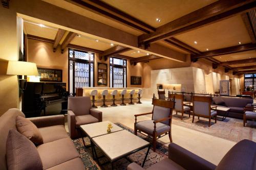 a lobby with a waiting room and a piano at Kempinski Hotel Ishtar Dead Sea in Sowayma