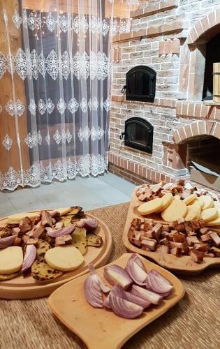 a table with plates of food and a brick oven at Casa Obcina Bucovinei in Fundu Moldovei