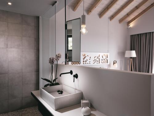 a bathroom with a sink and a mirror at Hotel St.John Suites Adults Only in Tsilivi