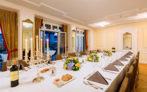 a large dining room with a long table with flowers at Hotel Des Alpes in Luzern