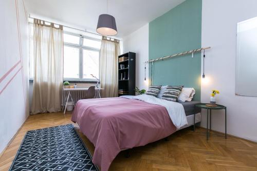 ein Schlafzimmer mit einem Bett und einer blauen Wand in der Unterkunft Apartments Ve Smeckach 27 in Prag