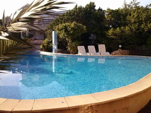 a swimming pool with lounge chairs and a swimming pool at casabellavista in Bonifacio