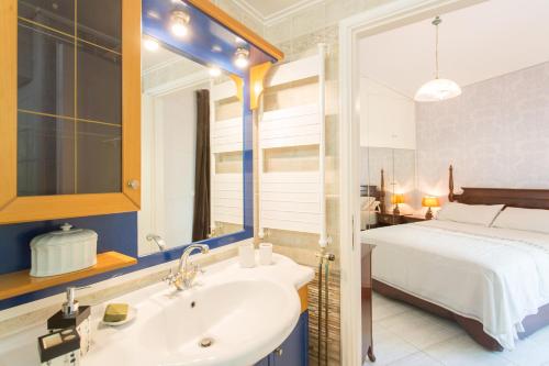 a bathroom with a white sink and a bed at Villa Maya in Pallíni