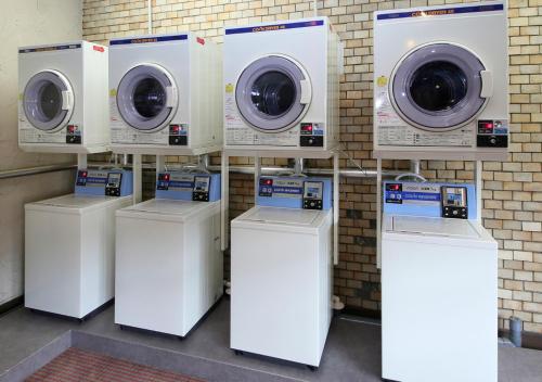 a row of washers and dryers in a room at New Miyako Hotel Ashikaga Annex in Ashikaga