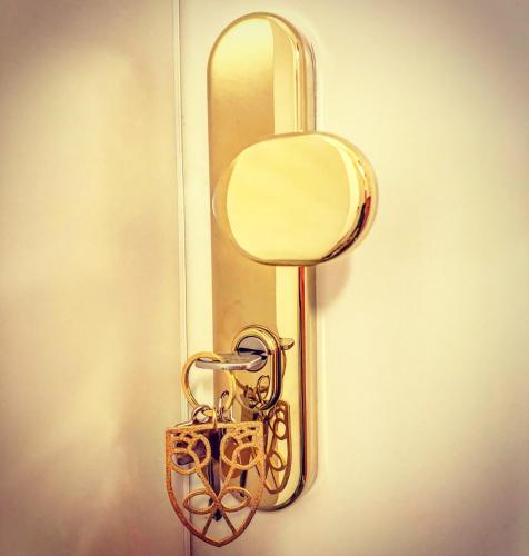 a gold door handle with a mirror and a purse at Victoria Hotel in Düsseldorf