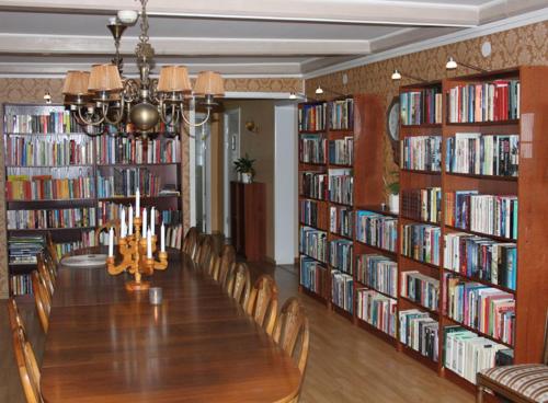 Pensionat Klåvasten في سكوفدي: طاولة طويلة في مكتبة بها العديد من الكتب