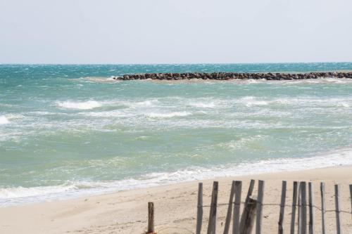 a beach with a row of wooden poles in the sand at ibis Styles Perpignan Canet En Roussillon in Canet-en-Roussillon