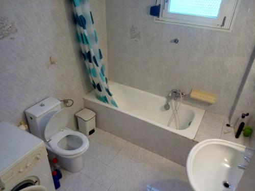ein Badezimmer mit einer Badewanne, einem WC und einem Waschbecken in der Unterkunft Kounis Villa in Chalkida