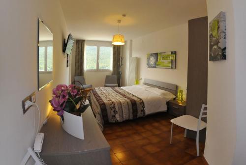 ein Hotelzimmer mit einem Bett, einem Tisch und Stühlen in der Unterkunft Hotel Piancastello in Andalo