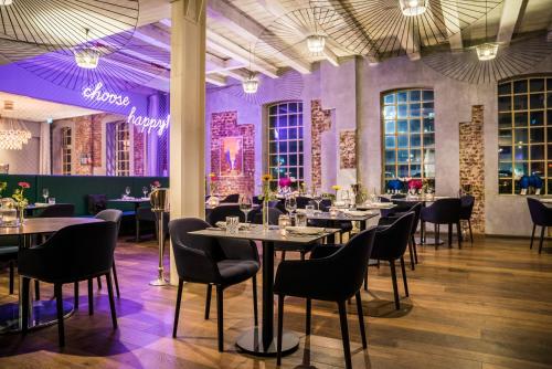 une salle à manger avec des tables, des chaises et un éclairage violet dans l'établissement Hotel & Restaurant Heyligenstaedt, à Giessen