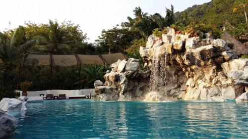 a pool at a resort with a rock waterfall at Koh Tao Cabana in Koh Tao