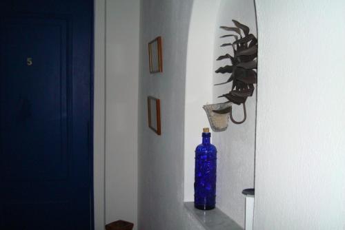 a blue bottle sitting on a shelf in a room at Nostos Studios in Parikia