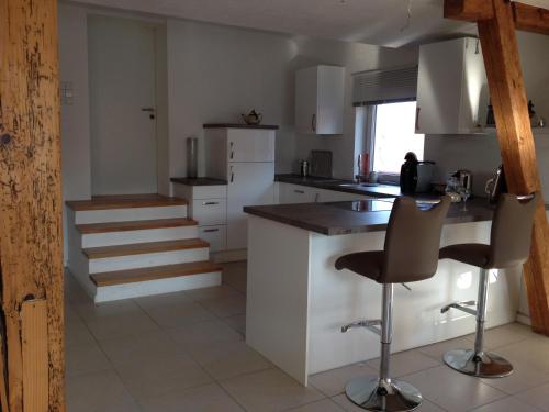 a kitchen with a counter and some chairs in it at Ferienwohnung-Dorothe in Rheinau