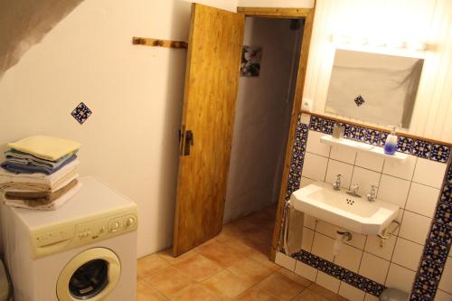 une salle de bain avec une machine à laver et un lavabo dans l'établissement Maison près Cité de Carcassonne, à Villalier