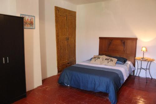 une chambre avec un lit avec une tête de lit en bois dans l'établissement Maison près Cité de Carcassonne, à Villalier
