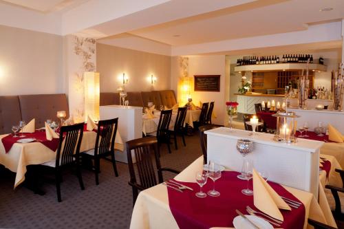 a restaurant with tables and chairs in a room at Hotel Rosenflora in Nideggen