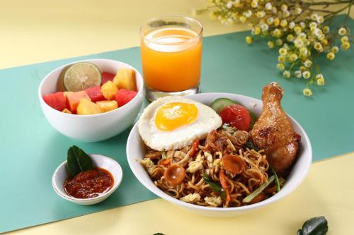 a bowl of food with an egg and a bowl of fruit at POP! Hotel Tebet Jakarta in Jakarta