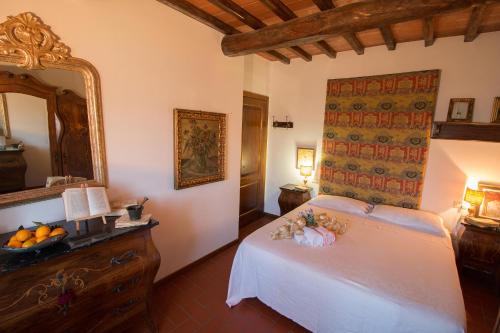 a bedroom with a white bed and a mirror at La Magione dei Todaro in Borgo a Buggiano