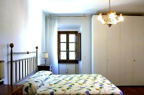 Un dormitorio con una cama y una lámpara de araña en Villa Enrica, en Santa Maria a Vezzano