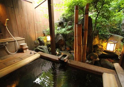 a pool of water with a monkey in the middle at Saikatei Jidaiya in Kaminoyama