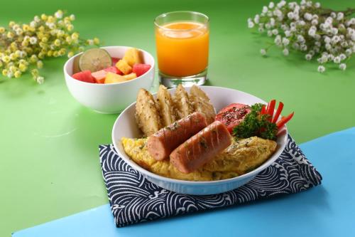 a bowl of food on a table with a bowl of fruit at POP! Hotel Tanjung Karang in Bandar Lampung