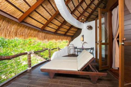 a porch with a bed and a table on it at Koh Tao Cabana in Koh Tao