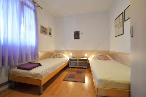 two twin beds in a room with a window at Holiday Apartment Ivan in Murter