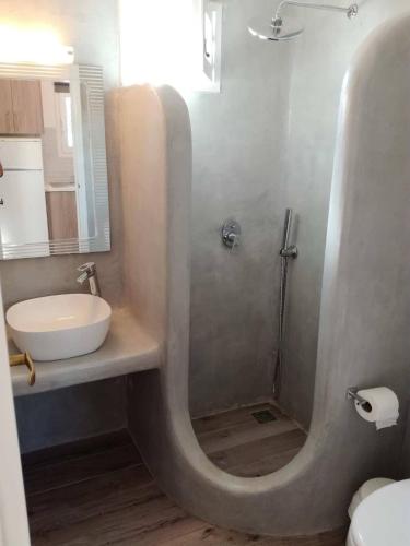 a bathroom with a shower with a sink and a toilet at Liana Studios in Mikonos