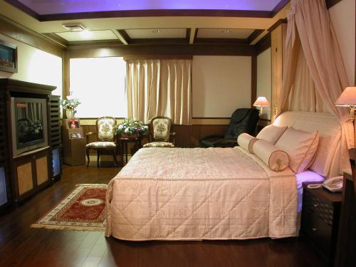 a bedroom with a large bed and a living room at Swan Lake Motel in Guishan