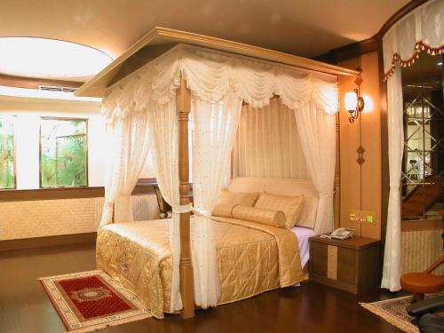 a bedroom with a bed with a canopy at Swan Lake Motel in Guishan