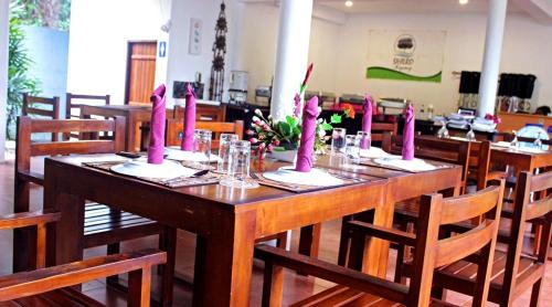 una mesa de madera con velas rosas encima en Sihilro Regency, en Udawalawe