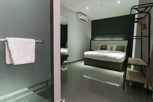 a bathroom with a bedroom with a bed and a shower at Hotel 99 Kota Kemuning in Shah Alam