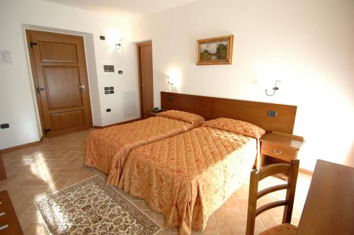 a bedroom with a bed and a wooden headboard at Colleverde Country House & SPA Urbino in Urbino