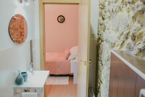 a small room with a bed and a bathroom at Ronda Navarra by Valdesierra in Béjar