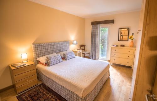 sypialnia z łóżkiem, komodą i oknem w obiekcie Funchal Arcadas Apartment by MLV w Funchal