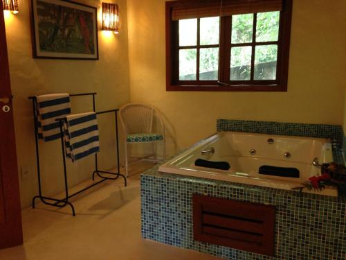 uma casa de banho com uma grande banheira num quarto em Atmosphera Pousada em Arraial d'Ajuda