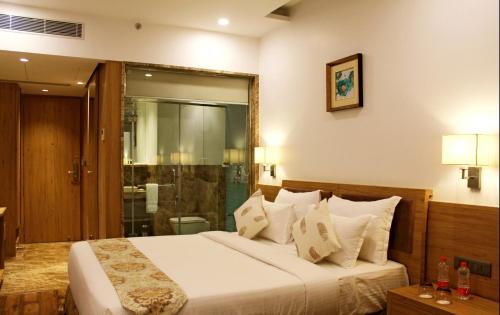 a bedroom with a large bed and a shower at SKK Blu Hotel & Spa in Udaipur