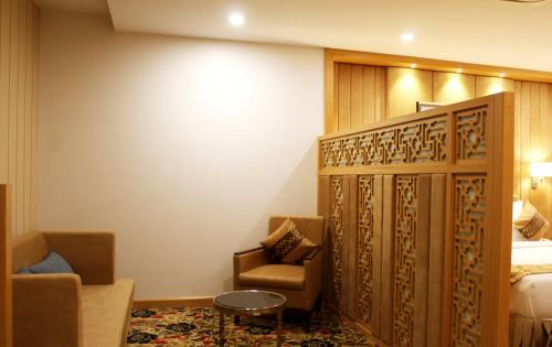 a hotel room with a chair and a bed at SKK Blu Hotel & Spa in Udaipur