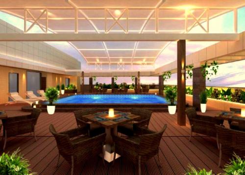 a resort with a pool and tables and chairs at SKK Blu Hotel & Spa in Udaipur