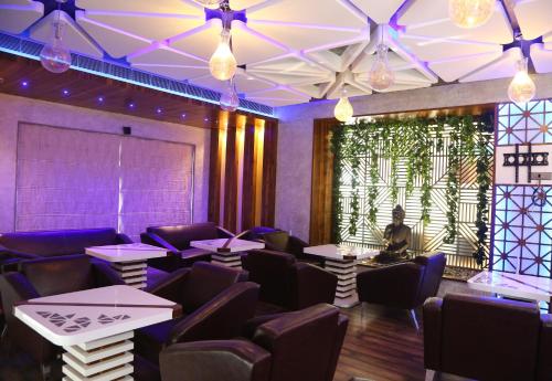a dining room with tables and chairs and lights at SKK Blu Hotel & Spa in Udaipur