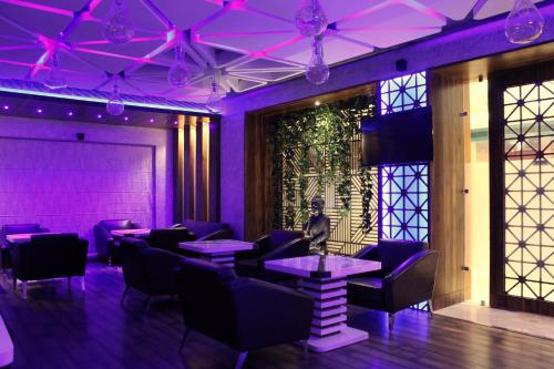 a restaurant with purple lighting and tables and chairs at SKK Blu Hotel & Spa in Udaipur