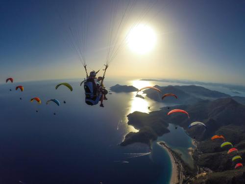 a person riding a parachute over a body of water at Sakura Hostel Fethiye in Fethiye