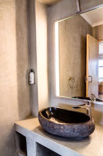 un bagno con un lavandino in pietra e uno specchio di Hotel A la Mer a Swakopmund
