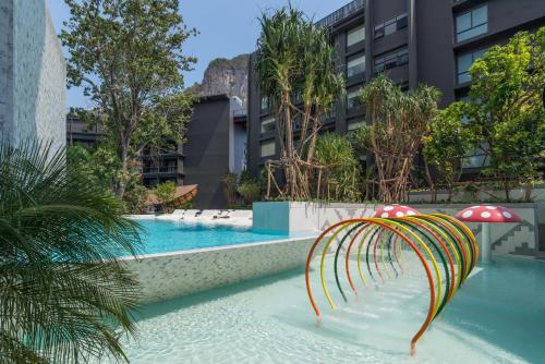 a swimming pool with a playground in a building at Panan Krabi Resort in Ao Nang Beach
