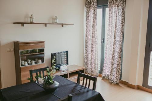 a dining room with a table and chairs and a desk at Ronda Navarra by Valdesierra in Béjar