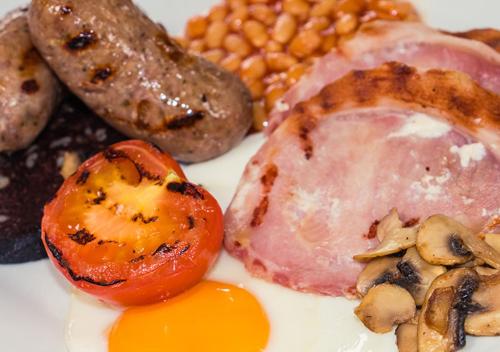 a plate of food with eggs sausage mushrooms and beans at Windy Harbour restaurant & b&b in Glossop